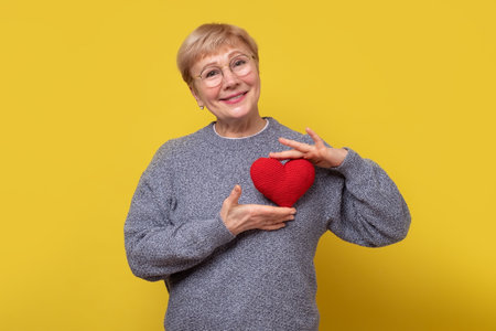 Woman with heart sign, showing her truthful feelings, has sympathy or taking care about health.の写真素材