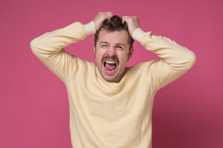 Shocked handsome guy holding hand on his head being in panic.の写真素材