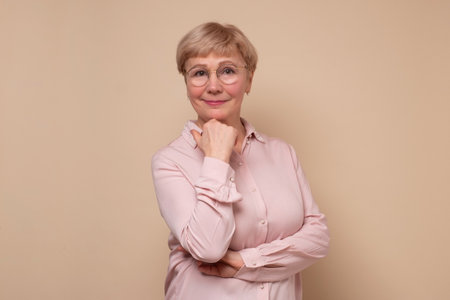 Aged caucasian lady with glasses posing to the camera smiling.の写真素材