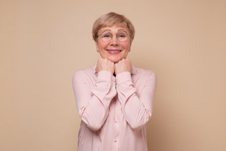 Mature woman in glasses being surprised with news.の写真素材