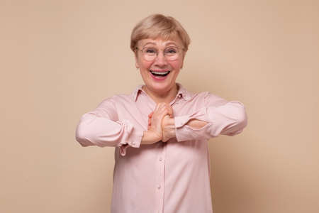 Amazed mature woman in glasses with opened mouth feels stunned after shocking new.の写真素材