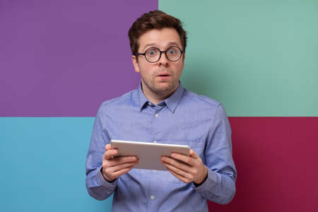 Mature european man using a digital tablet. He is puzzled and confused.