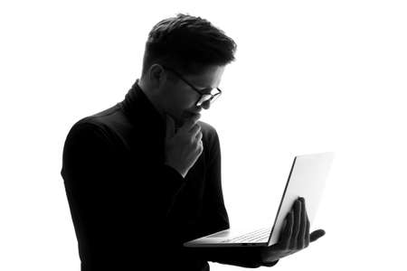 Supporting your business. Silhouette of man in glasses working on laptopの写真素材