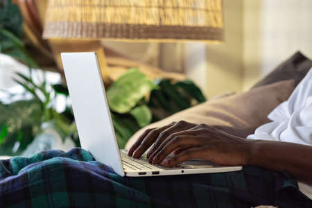 view shot of african male hands busy working on aptop sitting at home.