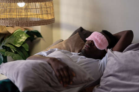Handsome ethnic black african man resting in bed sleeping or napping.の写真素材