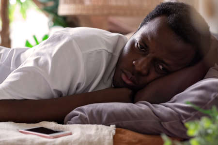 African tired man cannot sleep from insomnia