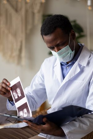 African doctor analyzing ultrasound results of his pacient.の写真素材