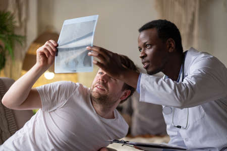 African doctor analyzing ultrasound results of his pacient.