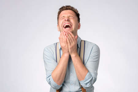 Young caucasian man laughing on funny joke.