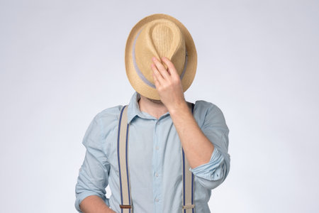 Young man in blue shirt covered his eyes by summer hat