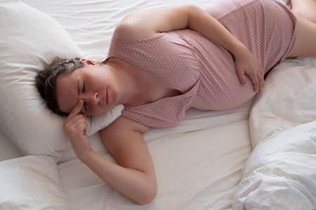 Worried pregnant woman in the bed suffering from insomniaの写真素材