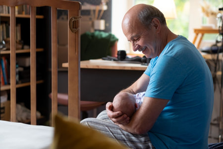 Grandfather holding a beautiful newborn baby girlの写真素材