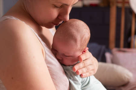 Caucasian mother holdin her newborn baby girl spending time together