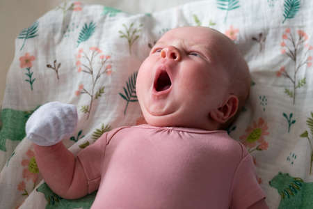 Yawning caucasian newborn baby taking a nap restingの写真素材
