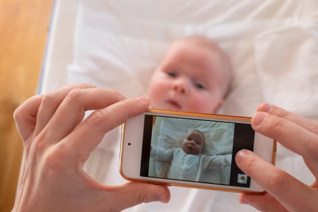 Mother make a portrait of her baby on mobile phone.の写真素材