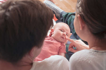 Happy parents holding their newborn baby girlの写真素材