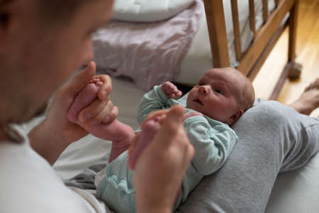 Hands holding baby feet checking reflex of a newborn.の写真素材