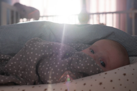 Funny caucasian baby lying on the bed.の写真素材