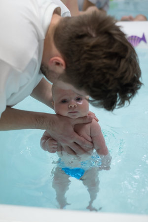 Caucasian 2 month baby exercising in swimming poolの写真素材