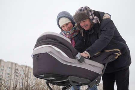 Mother and grandfather walking with child in stroller