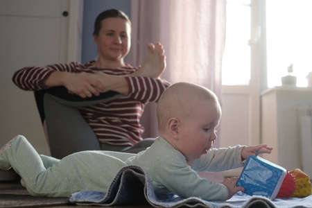 Mother with baby make yoga at home to be strong and healthy