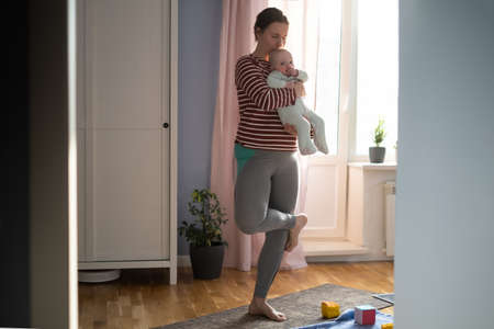 Mother with baby make yoga at home to be strong and healthy