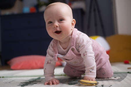 six months old caucasian baby on the floor with a toy