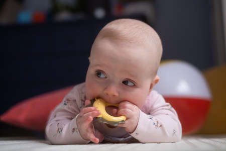six months old caucasian baby on the floor with a toy
