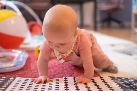 six months old caucasian baby on the floor with a toyの写真素材
