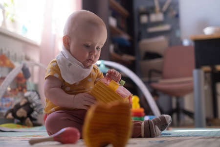 Caucasian baby toddler playing color blocks aloneの写真素材