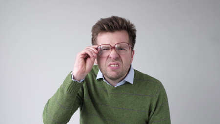 Curious scrupulous man looks attentively at one point, sees something strange or suspicious.