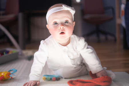 seven months old caucasian baby on the floor with a toyの写真素材