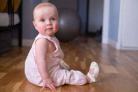 cute seven months old caucasian baby on the floorの写真素材