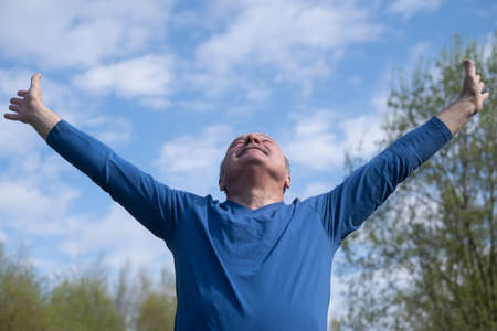 Senior runner with armband doing stretching. spring nature. Healthy lifestyle at old age.