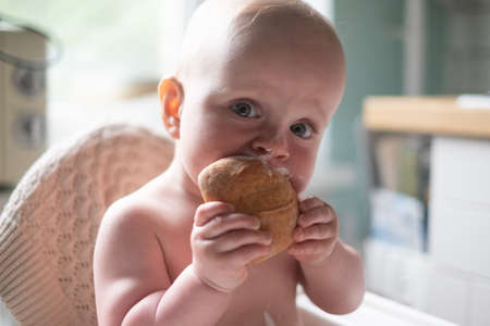 caucasian happy baby boy eating breakfast on the morning.の写真素材