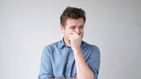 European young man barely holding back tears from problems and stress. studio shotの写真素材