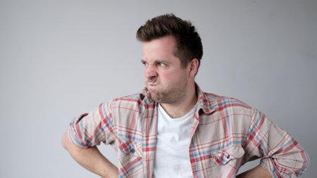 The European young man looks disappointedly sideways. He is unsatisfied with the results. studio shotの写真素材