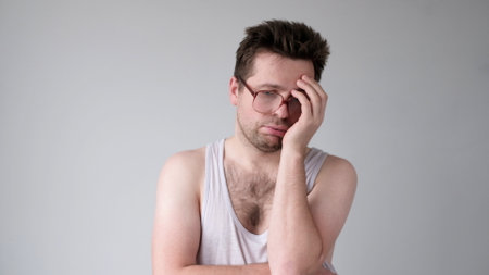 the tired European young man looks dejectedly, without strength and energy. studio shotの写真素材