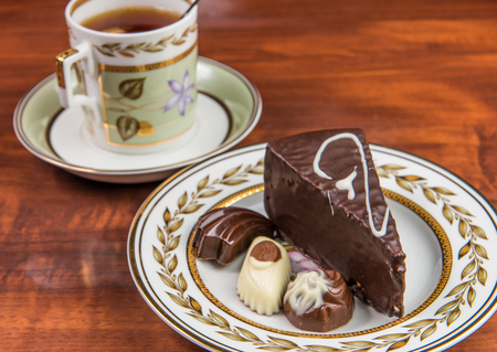 candies cake and cup of tea on the tableの写真素材