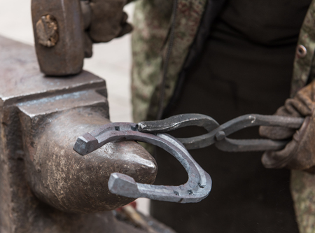 blacksmith makes horseshoe by toolsの写真素材