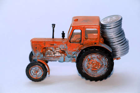 Toy tractor pulling bitcoin coins. Isolation on a white background.