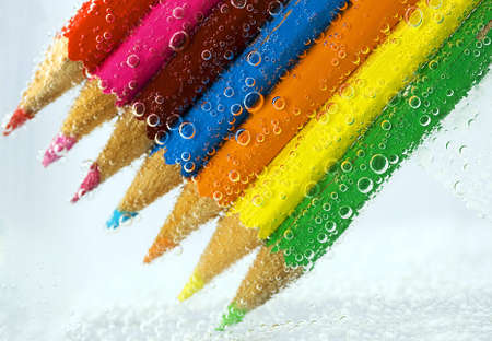colorful pencils, close-up on white background into water bubblesの写真素材
