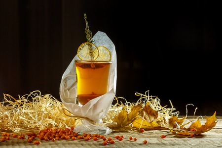Glass of iced tea with lemon on a windowsill. Glass and jar of iced tea with lemon on a windowsill. Iced tea with lemon slices and mint on rustic background.の写真素材