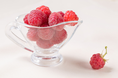 Ripe sweet raspberries in bowl on white table. Close up, top view, high resolution product.の写真素材