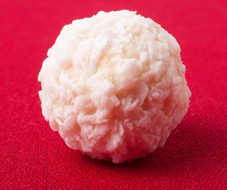 White coconut candy on red backgroundの写真素材