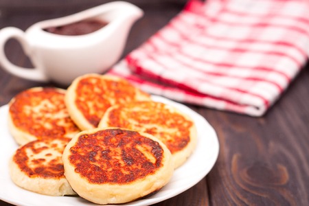 Beautiful golden cheese pancakes fried in a pan. Syrniki. Cottage cheese pancakes. Fritters of cottage cheese, traditional dish Ukrainian and Russian cuisine.の写真素材