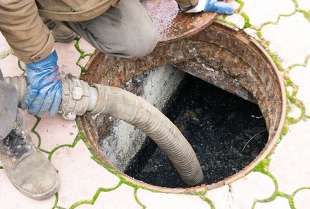man pumping sewage from the hole.の写真素材
