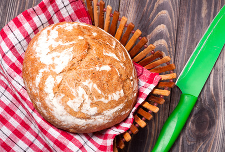 bread floured and knife placed on a wooden background.