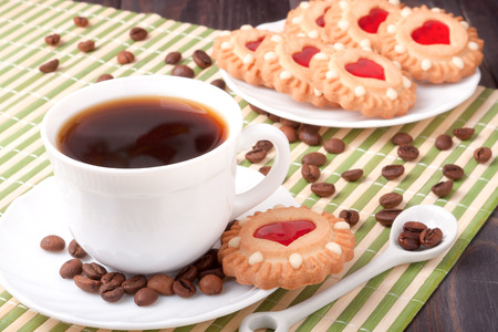 coffee cup with beans and cookies on the wooden table and a bamboo napkin .の写真素材