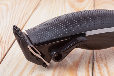 hair trimmer on a light wooden background closeup.